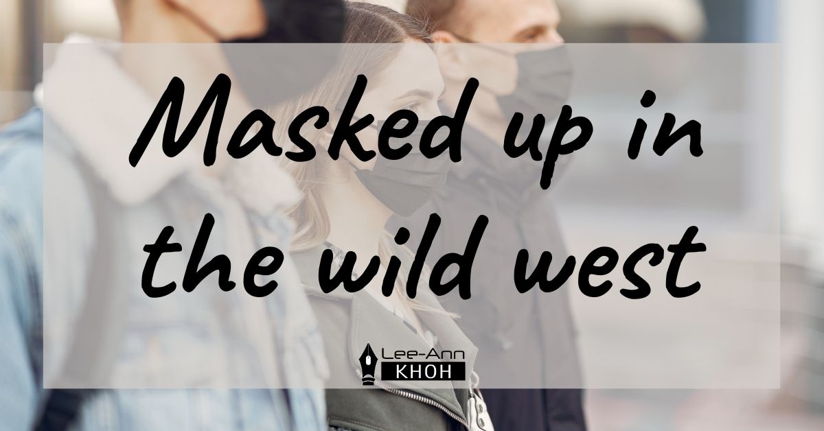 Text reads: Masked up in the wild west. Background contains 3 people wearing black face masks outside.