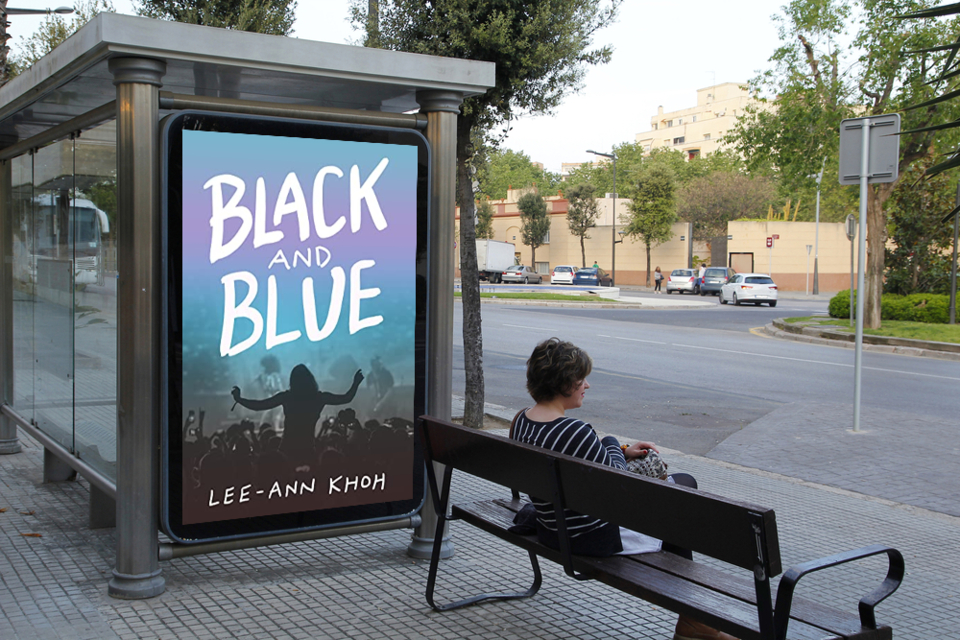 Mockup of Black and Blue by Lee-Ann Khoh displayed on the side of a bus shelter. A person sits on a bench looking out towards the street.
