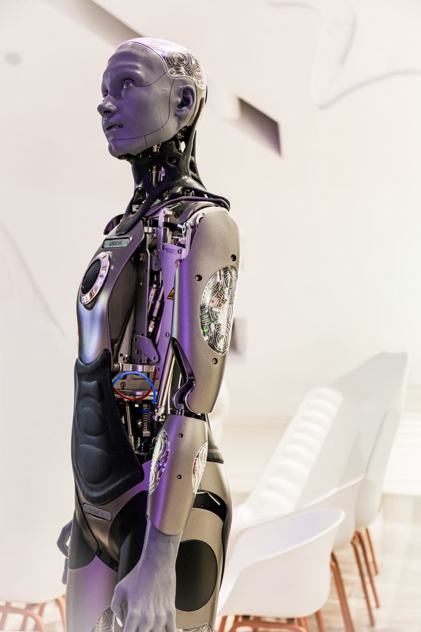 A futuristic humanoid robot standing in a white room.