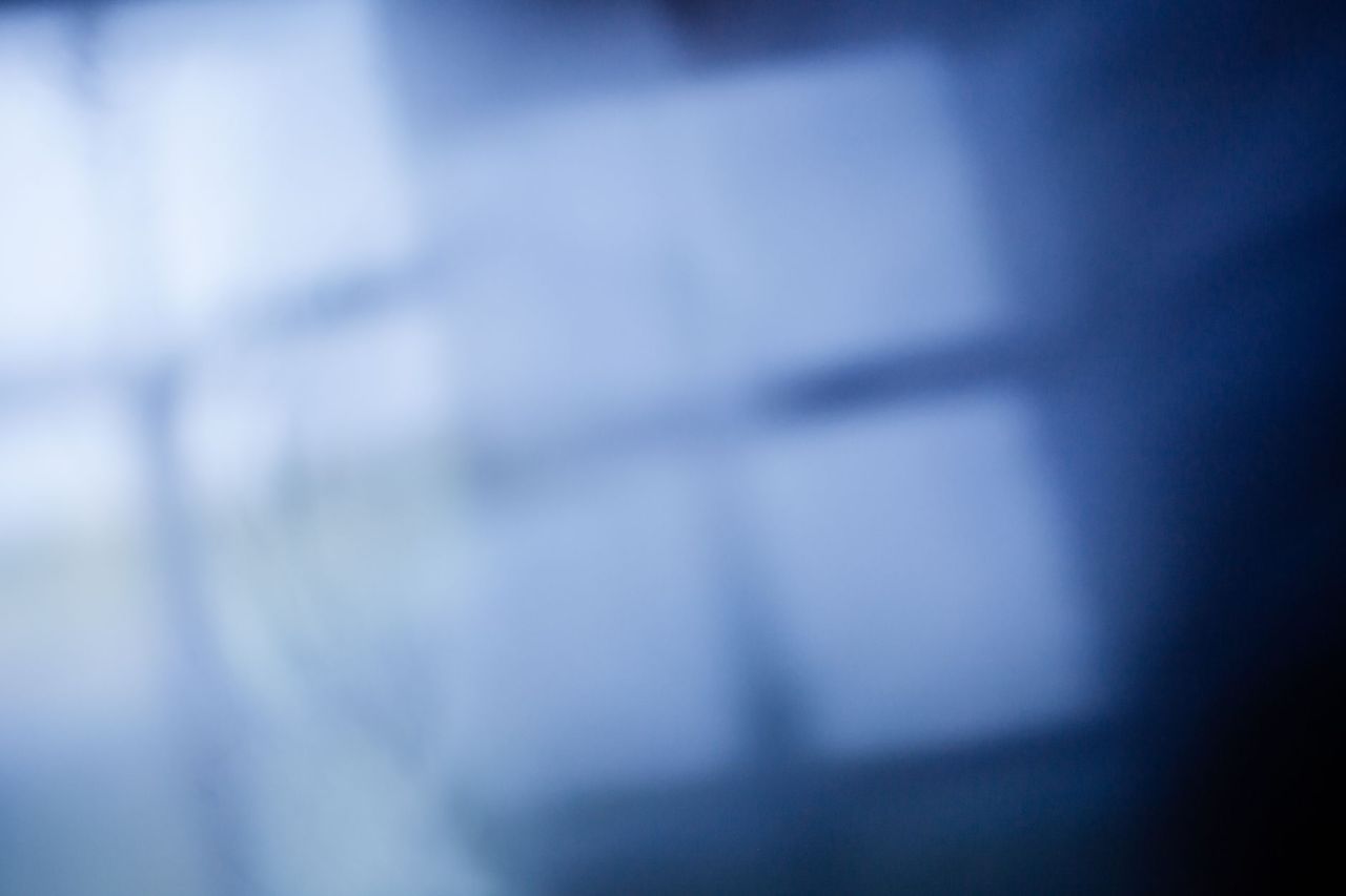 Blurred image of a blue room with the light reflection of a window.